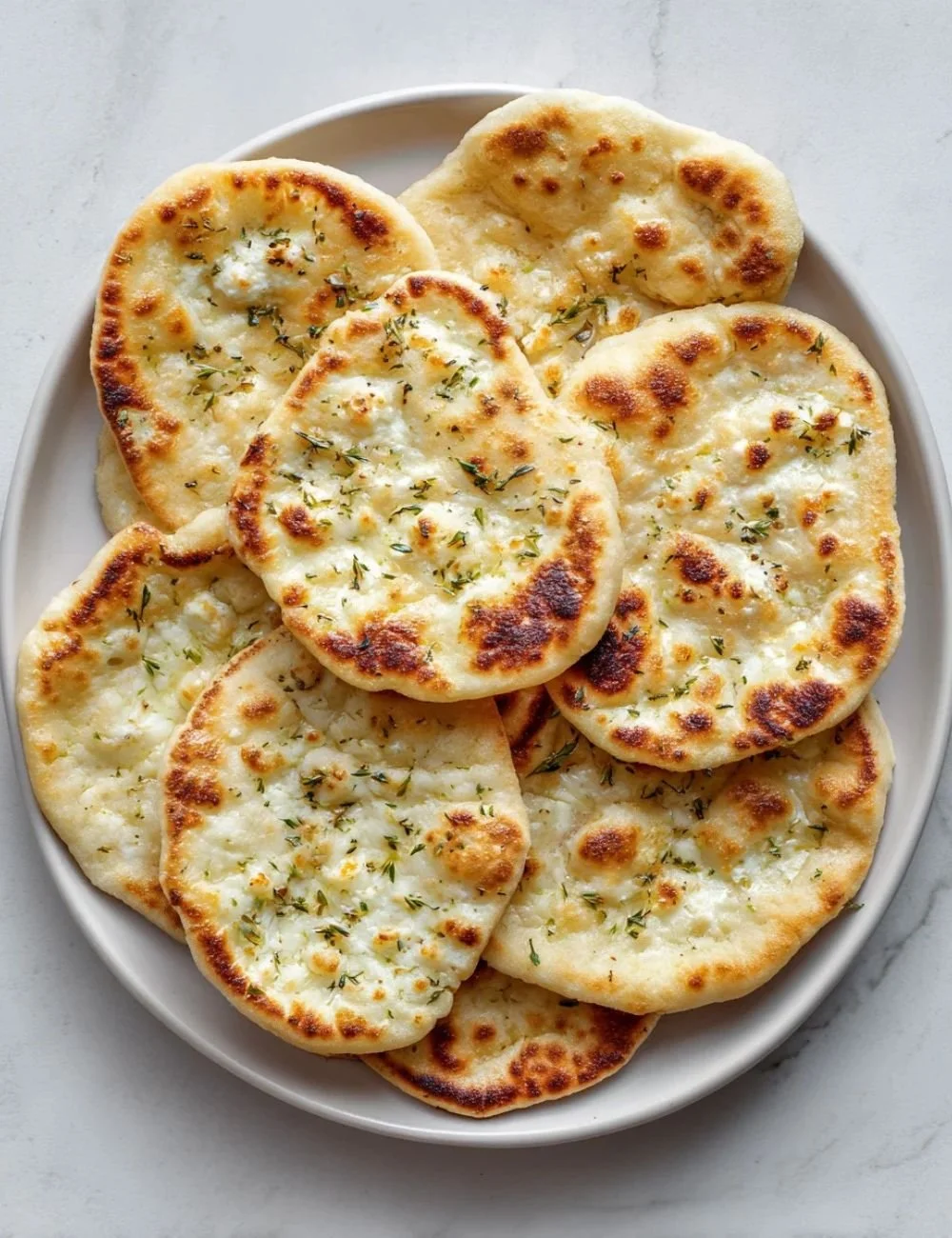 Homemade Cottage Cheese Flatbread served with fresh herbs and toppings.