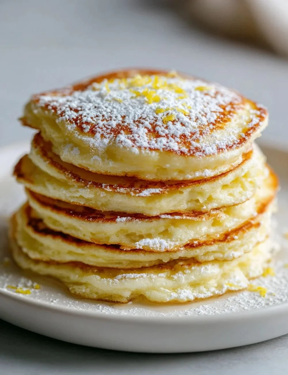 Fluffy lemon ricotta pancakes topped with fresh fruit and syrup