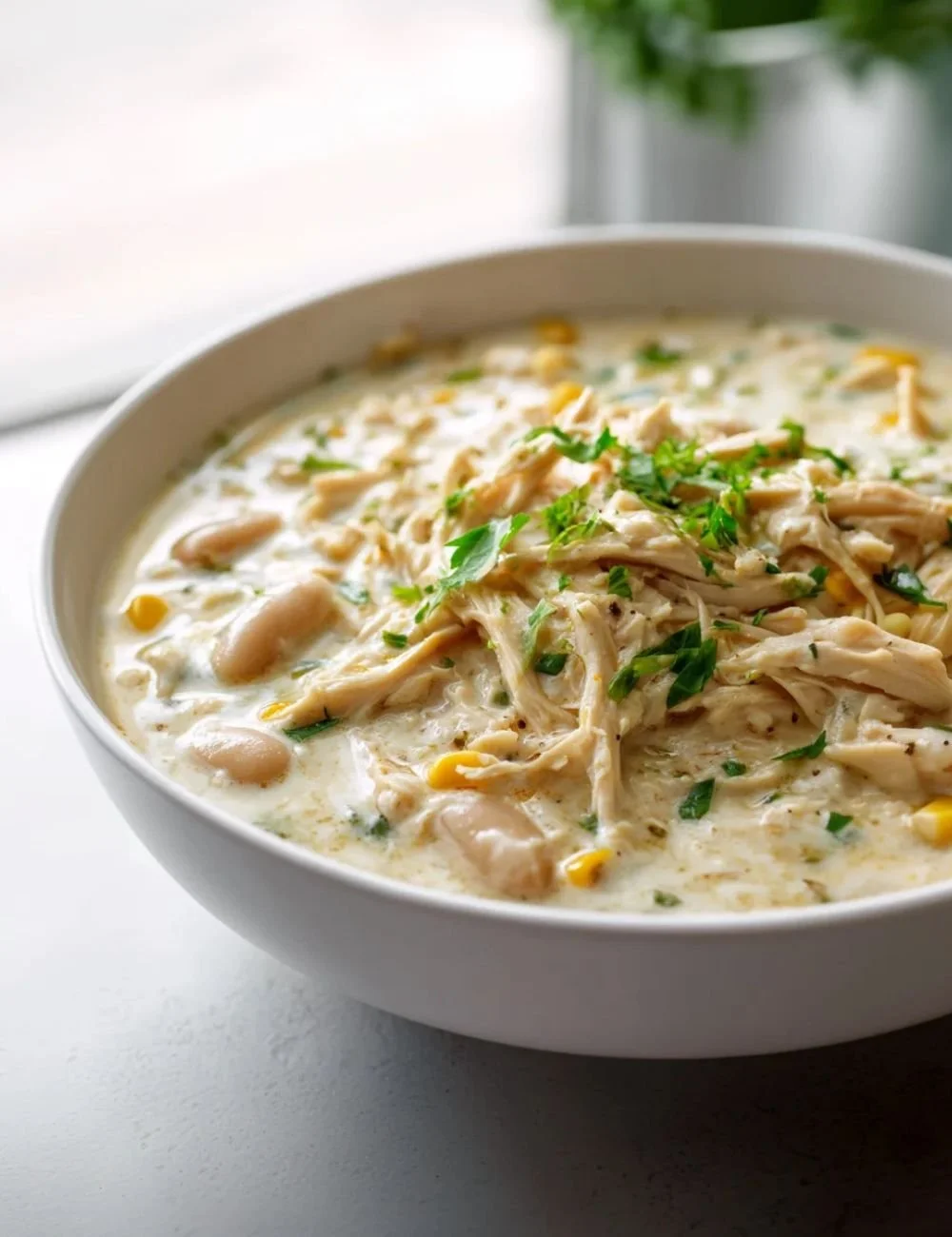 Creamy white chicken chili topped with herbs and served in a bowl