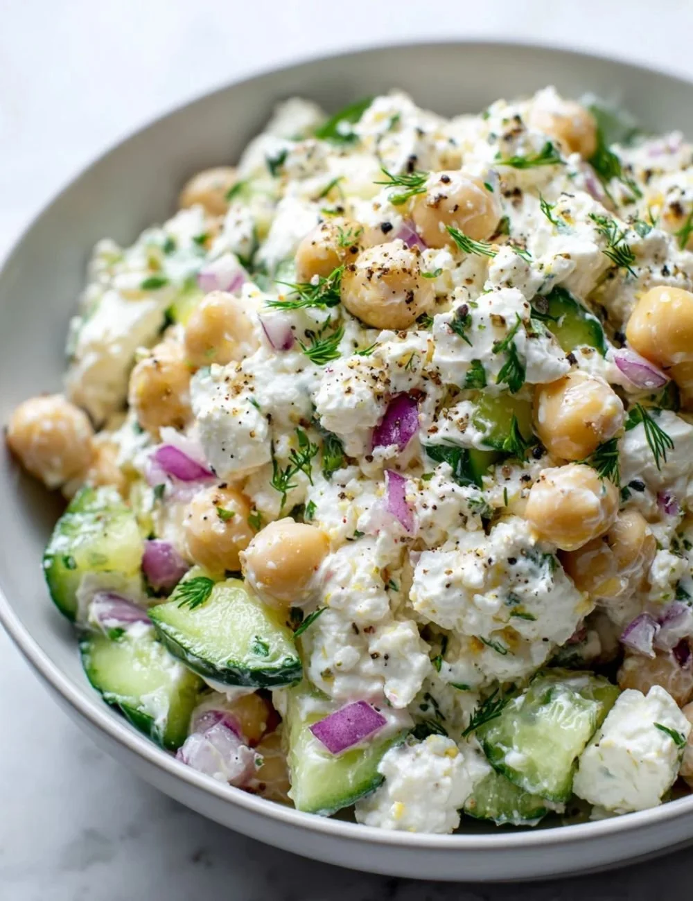 A colorful cottage cheese salad with fresh vegetables and herbs.