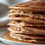 Fluffy gin gingerbread protein pancakes topped with syrup and spices.