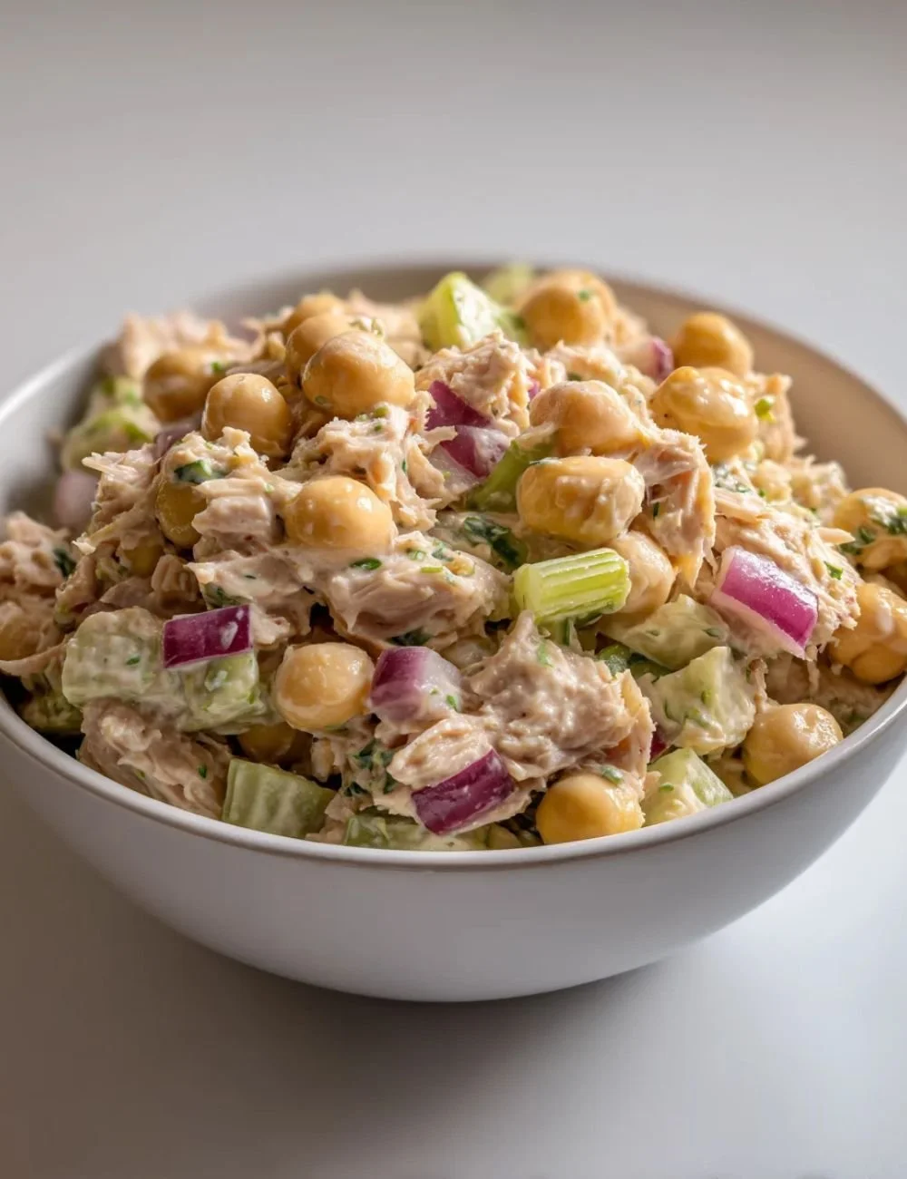 Bowl of healthy tuna chickpea salad with fresh vegetables and herbs