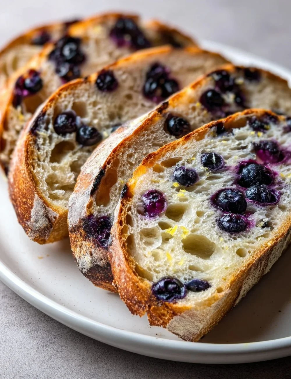 Lemon Blueberry Sourdough Bread with fresh blueberries on a wooden table.