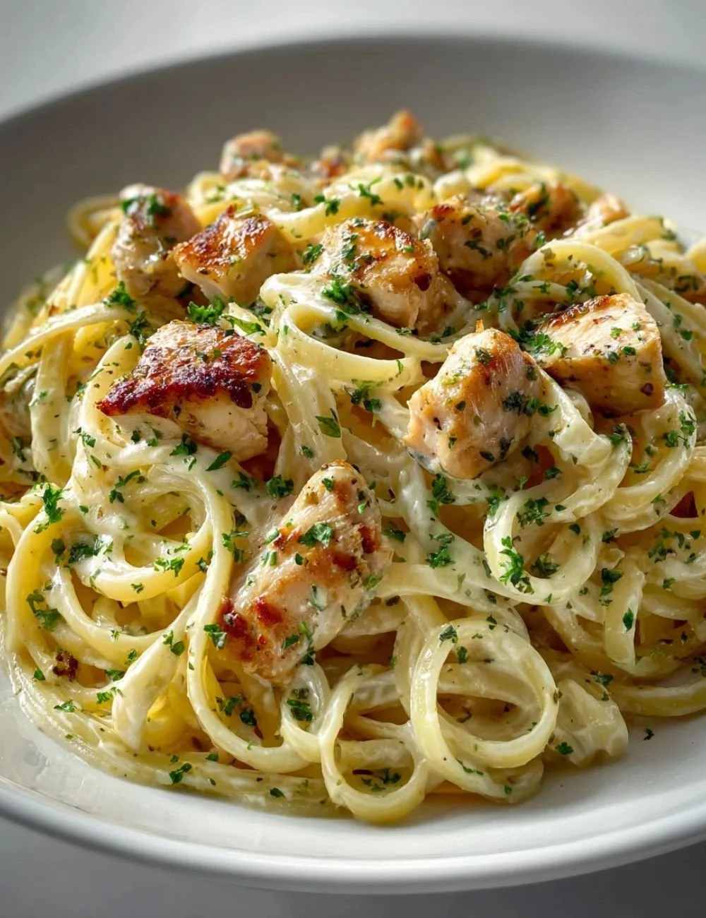 Plate of Lemon Butter Garlic Chicken Pasta with fresh herbs and lemon slices