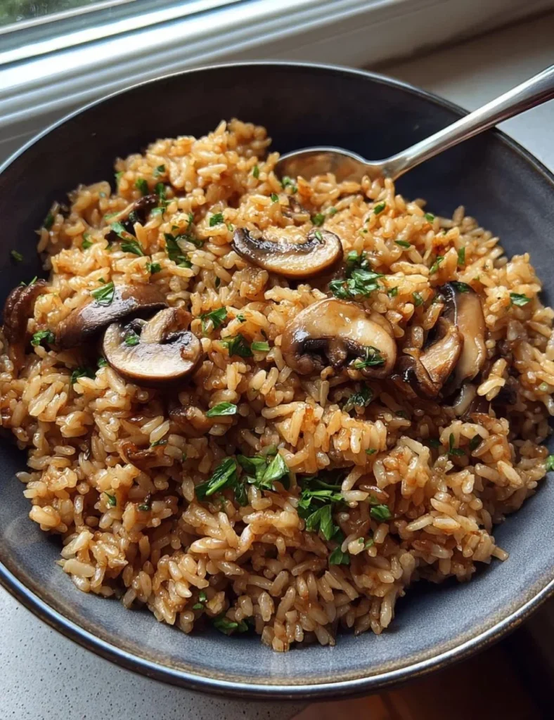 Delicious mushroom rice dish served on a plate with fresh herbs.