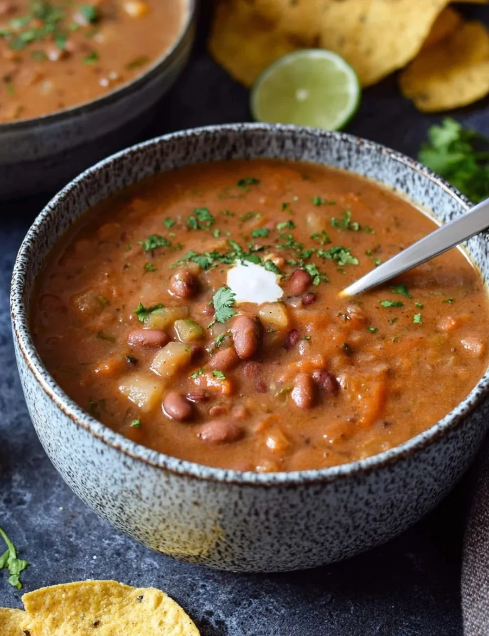 Bowl of delicious and hearty Pinto Bean Soup served with fresh herbs