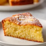 Flourless Lemon Almond Cake with a slice garnished with lemon zest and almonds