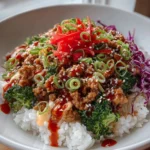 Ground turkey rice bowls topped with Bang Bang sauce, garnished with green onions.