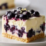 No bake lemon blueberry cake topped with fresh blueberries and lemon zest