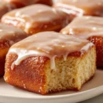 Soft baked maple donut bars with a glaze and sprinkles on a plate.