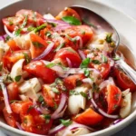 Fresh Artichoke Tomato Salad garnished with herbs