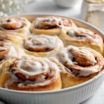 Freshly baked sourdough cinnamon rolls topped with creamy frosting.