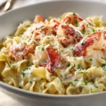 Creamy lobster tail pasta dish topped with Parmesan cheese