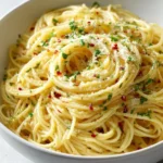 Plate of Italian pasta with garlic olive oil sauce garnished with herbs