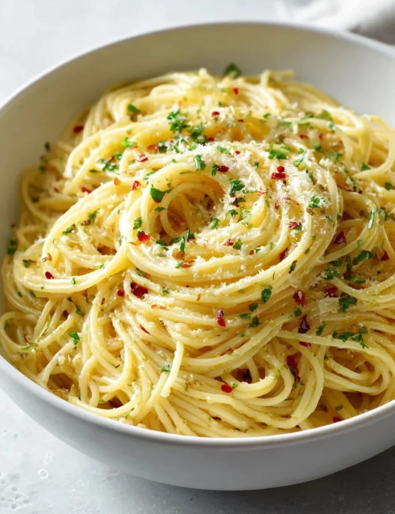 Plate of Italian pasta with garlic olive oil sauce garnished with herbs