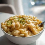 Jalapeño BBQ chicken protein mac served in a bowl, garnished with fresh herbs.