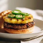 Pineapple Jalapeño Smash Burger with Hot Honey served on a wooden table