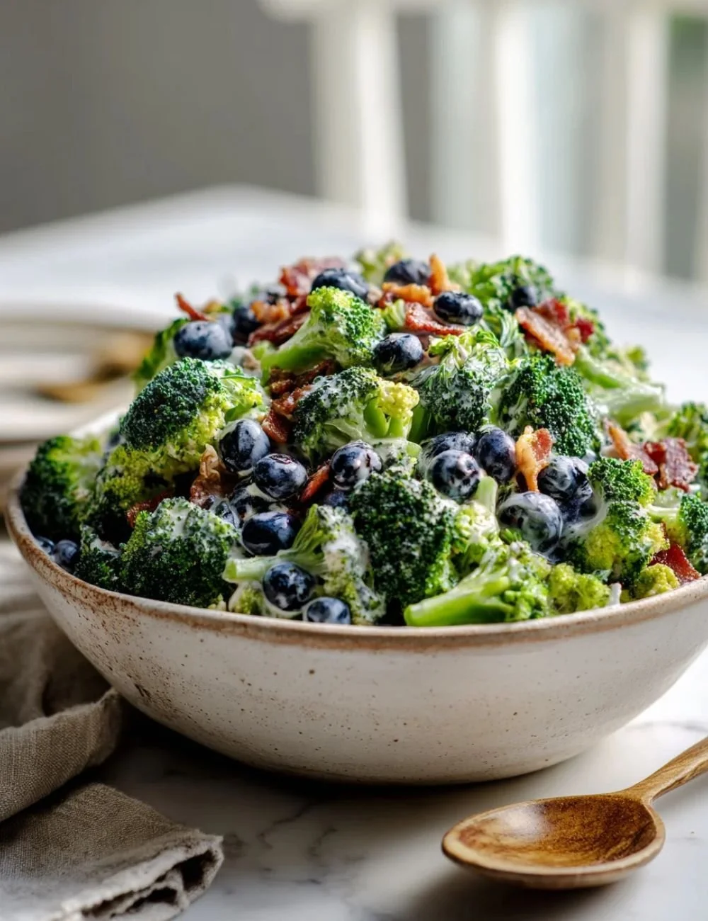 A colorful bowl of simple blueberry broccoli salad with nuts and dressing