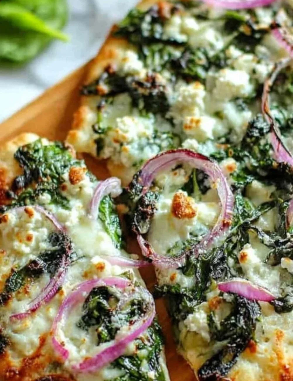 Delicious Spinach Feta Pizza served on a wooden board with fresh toppings.