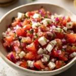 Delicious vibrant bruschetta dip served in a bowl with fresh tomatoes and basil