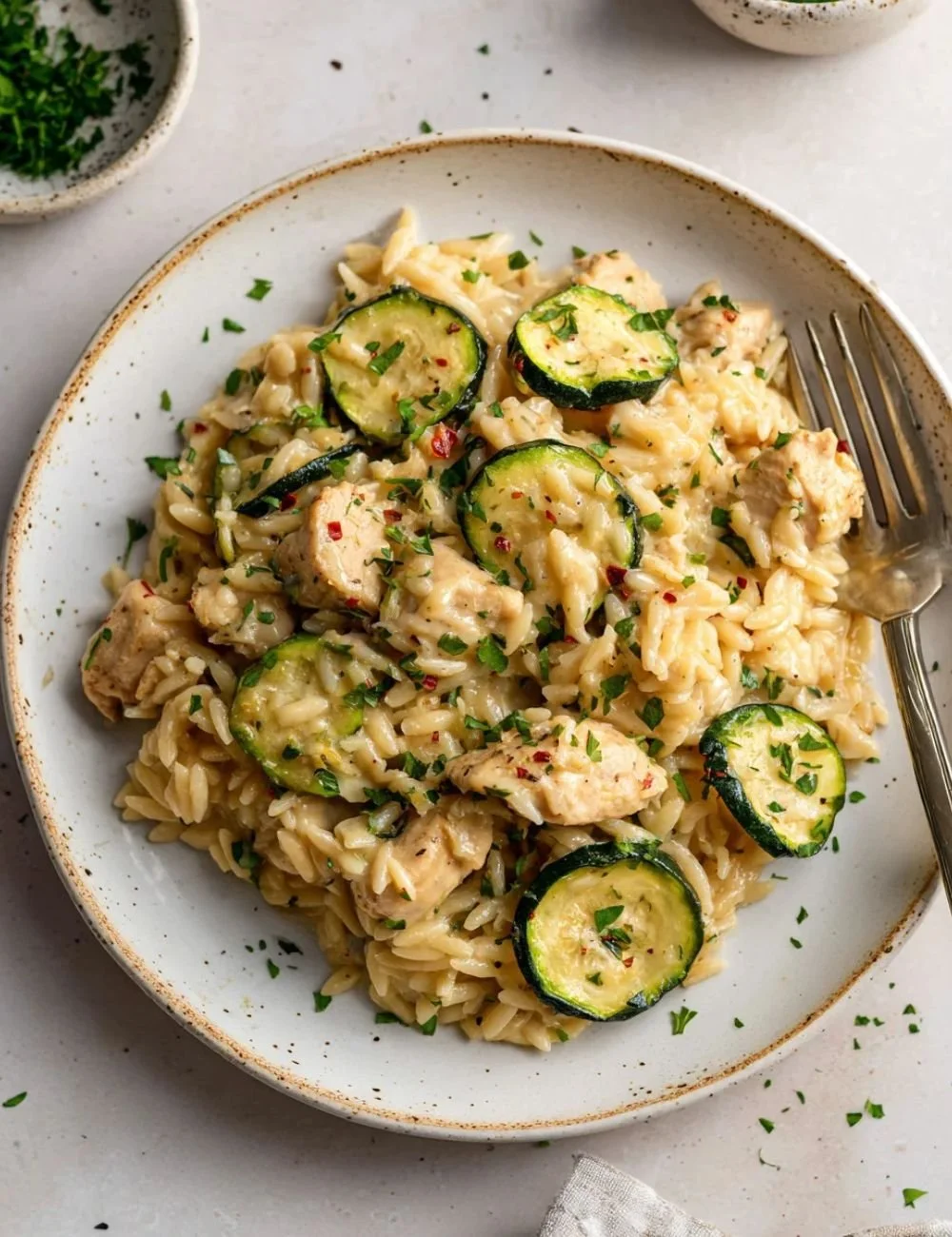 Zesty lemon butter chicken with orzo and zucchini served on a plate