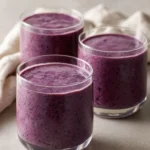Blueberry cottage cheese smoothie in a glass with fresh blueberries