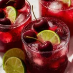 Chilled Cherry Limeade drink in a glass with cherry and lime garnish