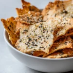 Homemade crispy sourdough crackers served on a wooden platter