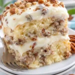 Delicious slice of homemade Italian Cream Cake topped with coconut and walnuts