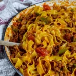 Plate of Italian Drunken Noodles garnished with fresh basil.